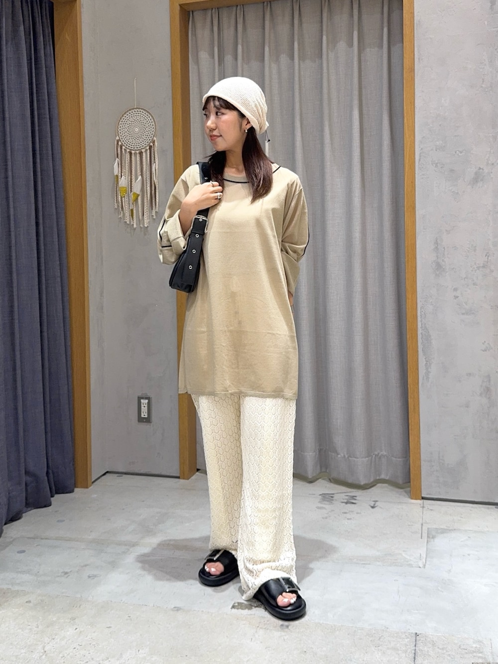 ベージュ系のニット/セーター、ブラック系のトートバッグ、ホワイト系のその他パンツを着用したレディースの夏コーディネートの2枚目の写真