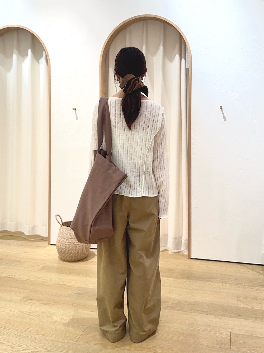 ホワイト系のカーディガン/ボレロ、ベージュ系のデニムパンツ、ブラウン系のトートバッグを着用したレディースの秋コーディネートの3枚目の写真