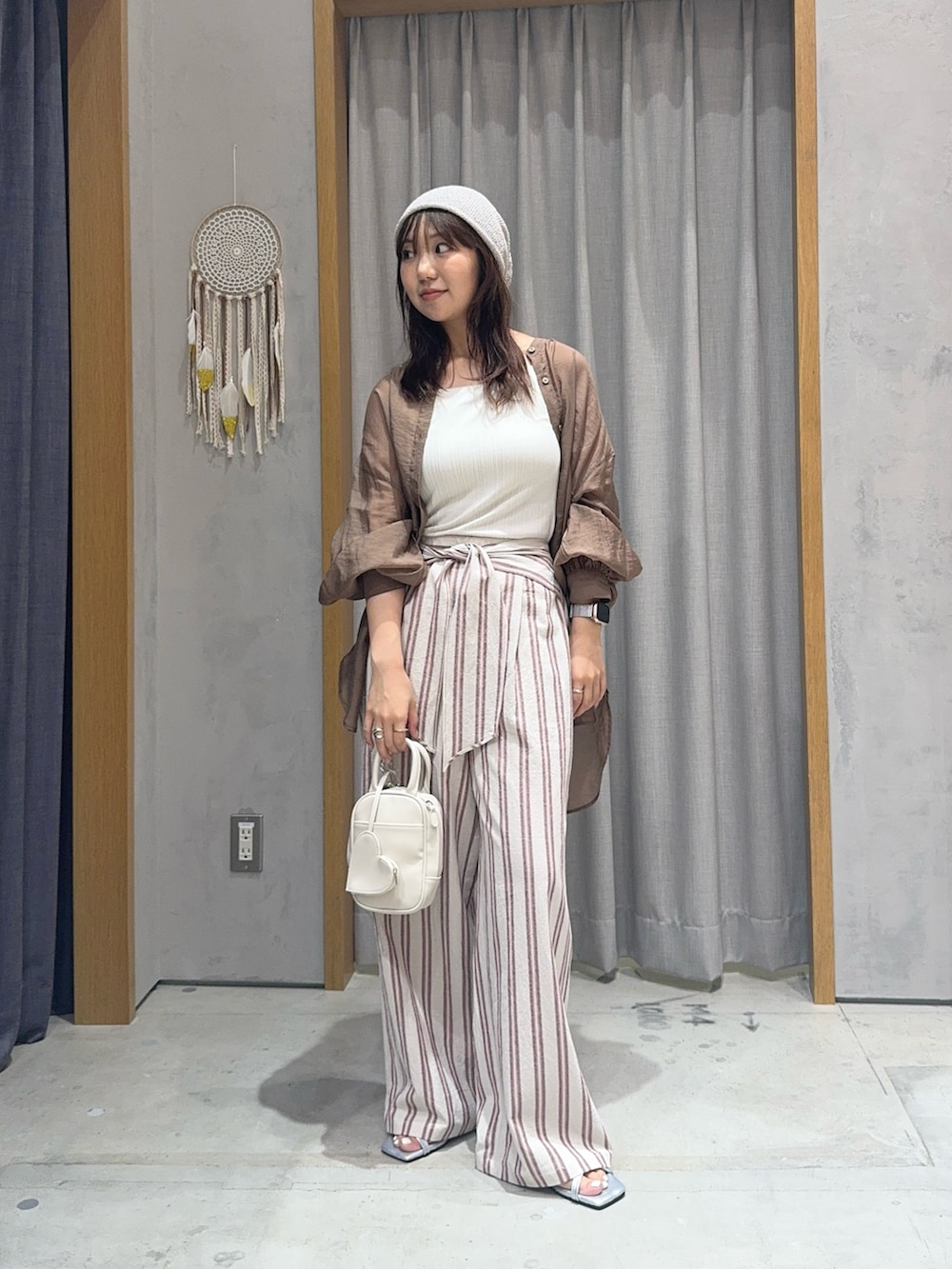 ホワイト系のその他パンツ、ブラウン系のシャツ/ブラウス、ホワイト系のトートバッグを着用したレディースの夏コーディネートの2枚目の写真