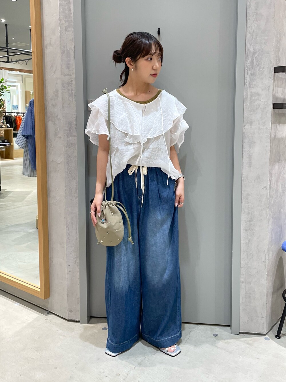 ホワイト系のシャツ/ブラウス、グリーン系のタンクトップ、ブルー系のデニムパンツを着用したレディースの夏コーディネートの2枚目の写真