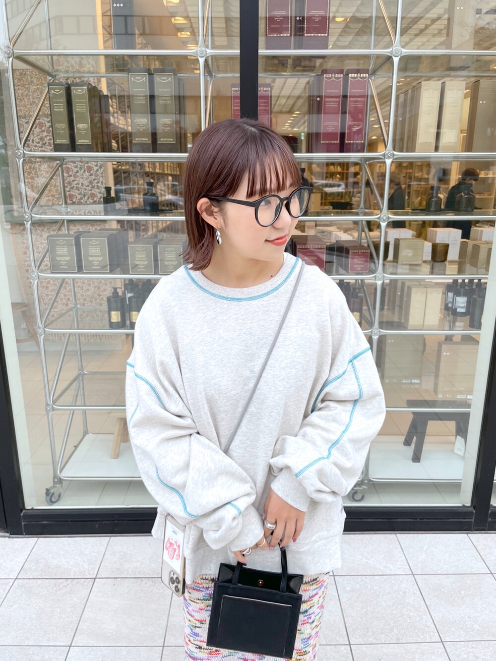 グレー系のスウェット、ピンク系のスカート、ピンク系のスニーカーを着用したレディースの秋コーディネートの5枚目の写真