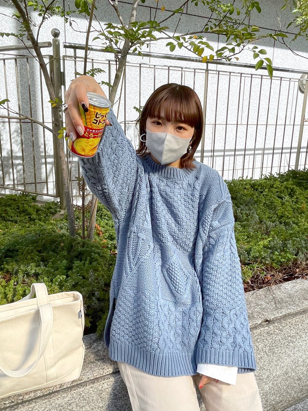 ブルー系のニット/セーター、ホワイト系のチノパンツ、ホワイト系のトートバッグを着用したレディースの秋コーディネートの3枚目の写真