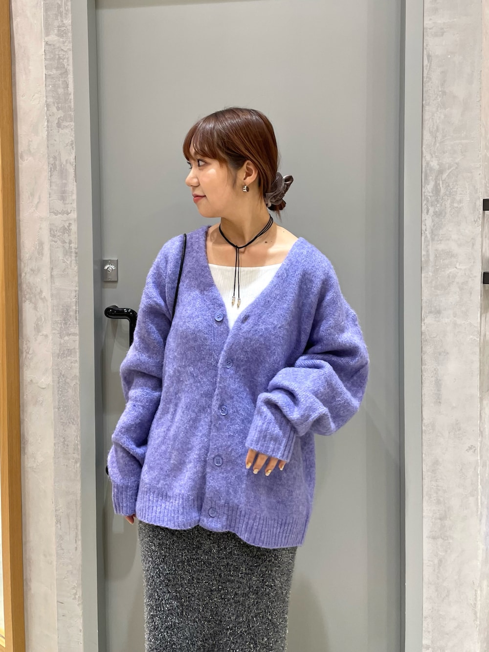 パープル系のカーディガン/ボレロ、ブラック系のバッグ、ブラック系のスカートを着用したレディースの秋コーディネートの3枚目の写真