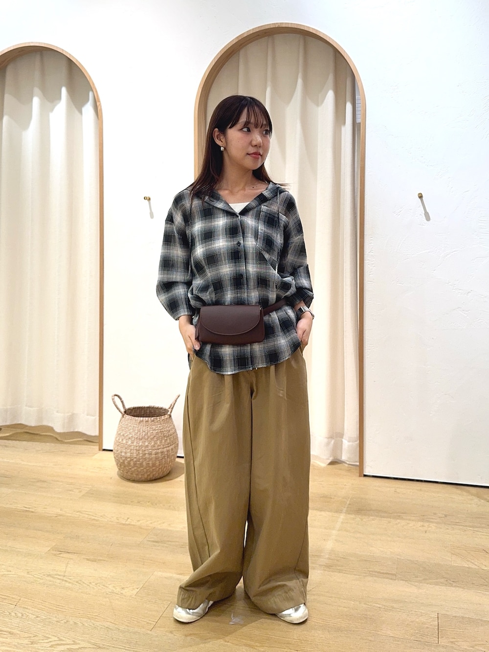 ブラック系のシャツ/ブラウス、ブラウン系のショルダーバッグ、ベージュ系のデニムパンツを着用したレディースの秋コーディネートの2枚目の写真