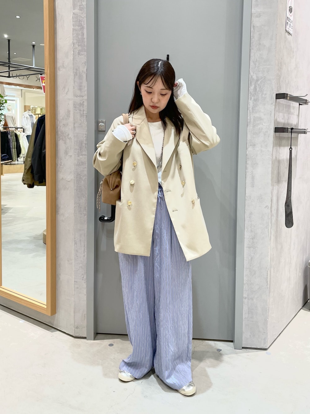 ベージュ系のテーラードジャケット、ホワイト系のTシャツ/カットソー、ブルー系のその他パンツを着用したレディースの春コーディネートの2枚目の写真