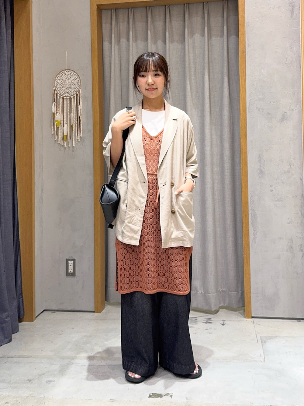 ベージュ系のテーラードジャケット、イエロー系のニット/セーター、ホワイト系のTシャツ/カットソーを着用したレディースの夏コーディネートの2枚目の写真