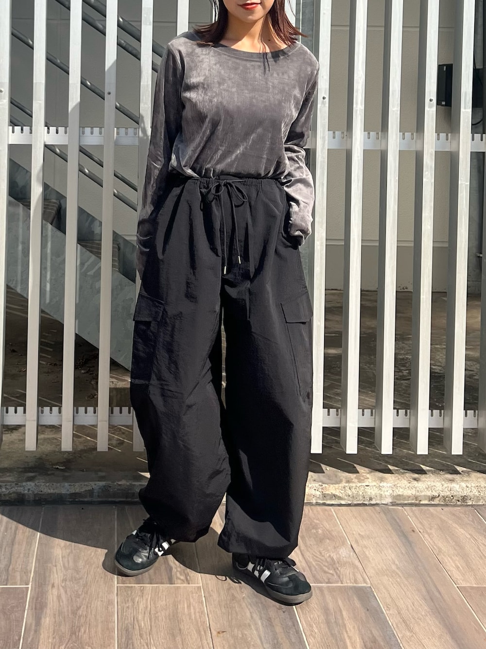 グレー系のTシャツ/カットソー、ブラック系のカーゴパンツ、ピンク系のショルダーバッグを着用したレディースの秋コーディネートの4枚目の写真