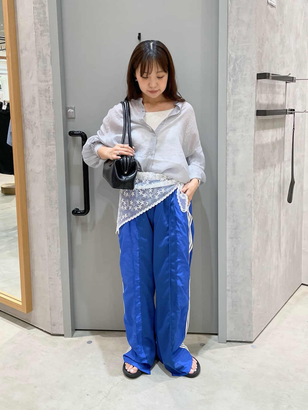 ブルー系のスウェットパンツ、グレー系のシャツ/ブラウス、ブラック系のトートバッグを着用したレディースの夏コーディネートの2枚目の写真