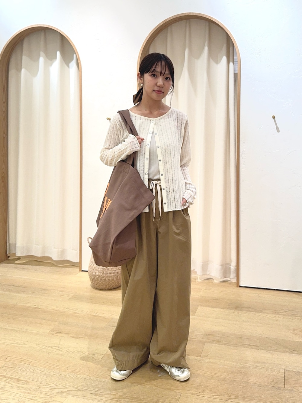 ホワイト系のカーディガン/ボレロ、ベージュ系のデニムパンツ、ブラウン系のトートバッグを着用したレディースの秋コーディネートの2枚目の写真