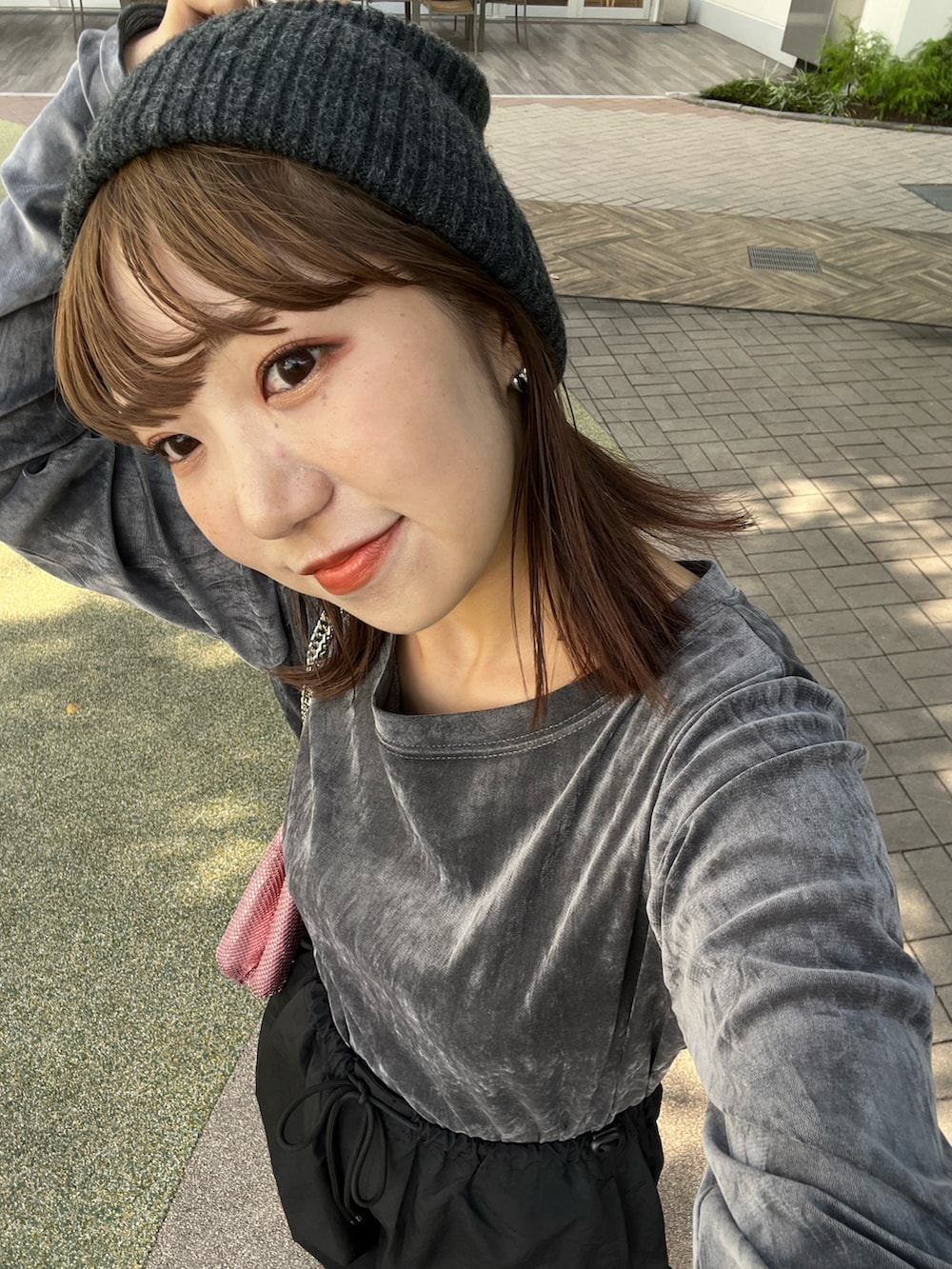 グレー系のTシャツ/カットソー、ブラック系のカーゴパンツ、ピンク系のショルダーバッグを着用したレディースの秋コーディネートの5枚目の写真