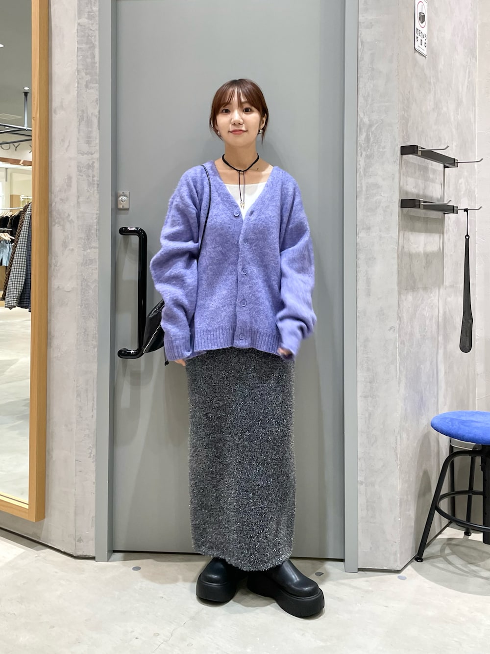 パープル系のカーディガン/ボレロ、ブラック系のバッグ、ブラック系のスカートを着用したレディースの秋コーディネートの2枚目の写真