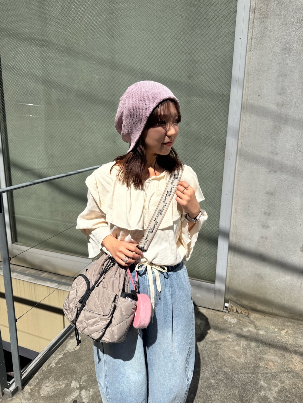 ホワイト系のTシャツ/カットソー、ブルー系のデニムパンツ、グレー系のショルダーバッグを着用したレディースの春コーディネートの3枚目の写真