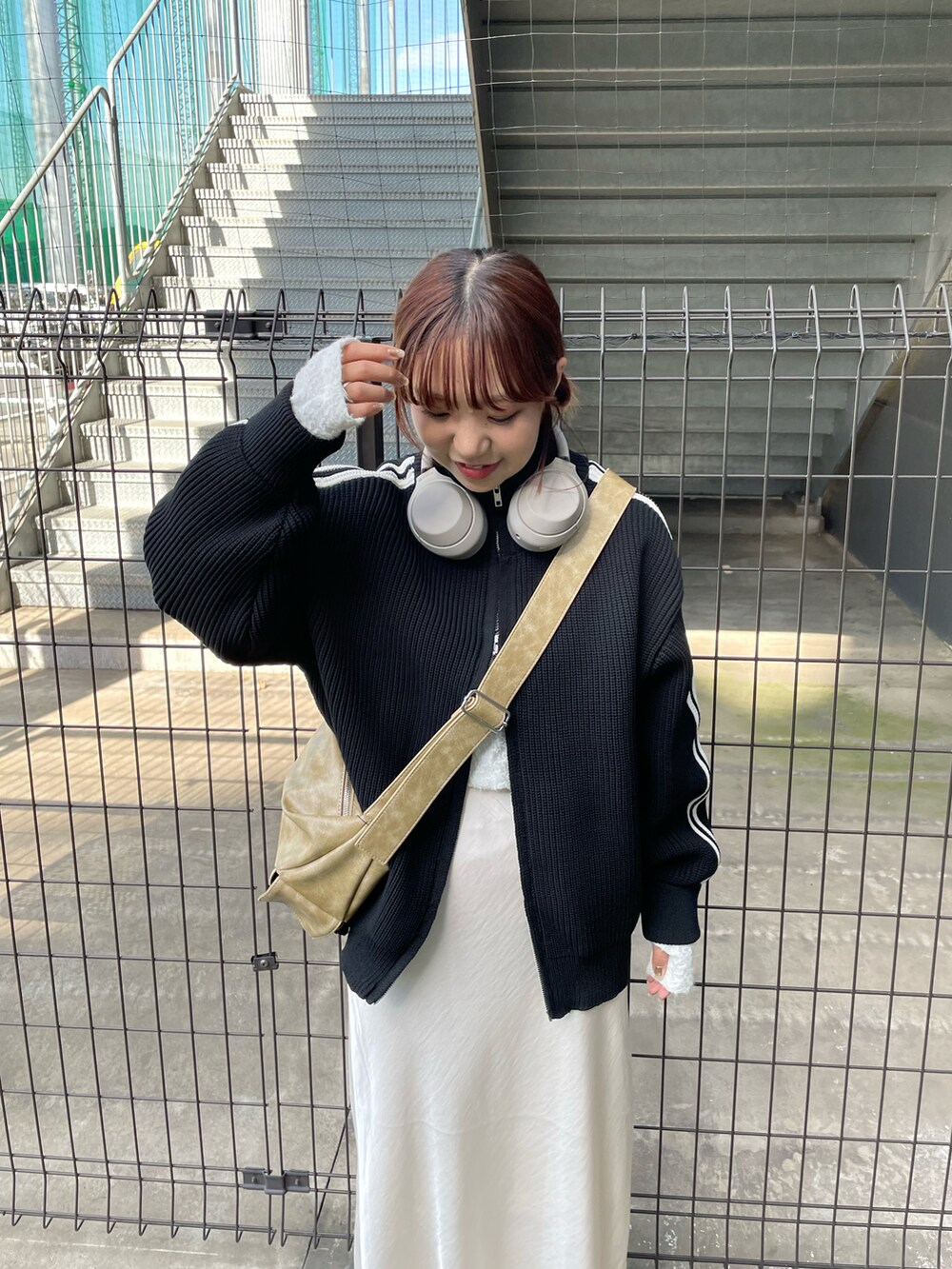 ベージュ系のショルダーバッグ、ホワイト系のスカート、ブラック系のニット/セーターを着用したレディースの秋コーディネートの3枚目の写真