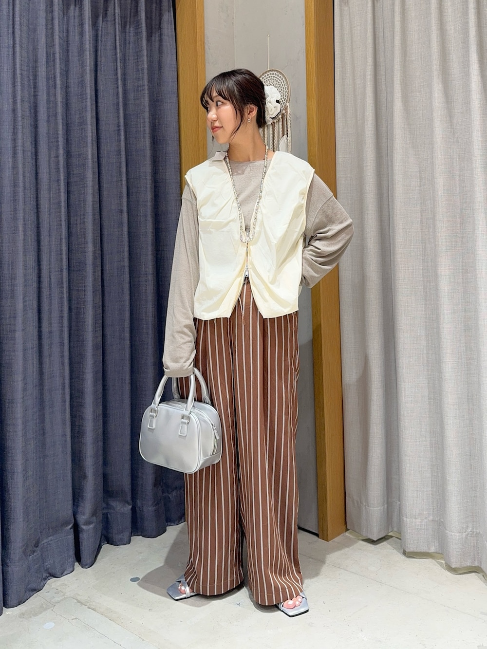 ブラウン系のその他パンツ、ベージュ系のTシャツ/カットソー、シルバー系のショルダーバッグを着用したレディースの春コーディネートの2枚目の写真