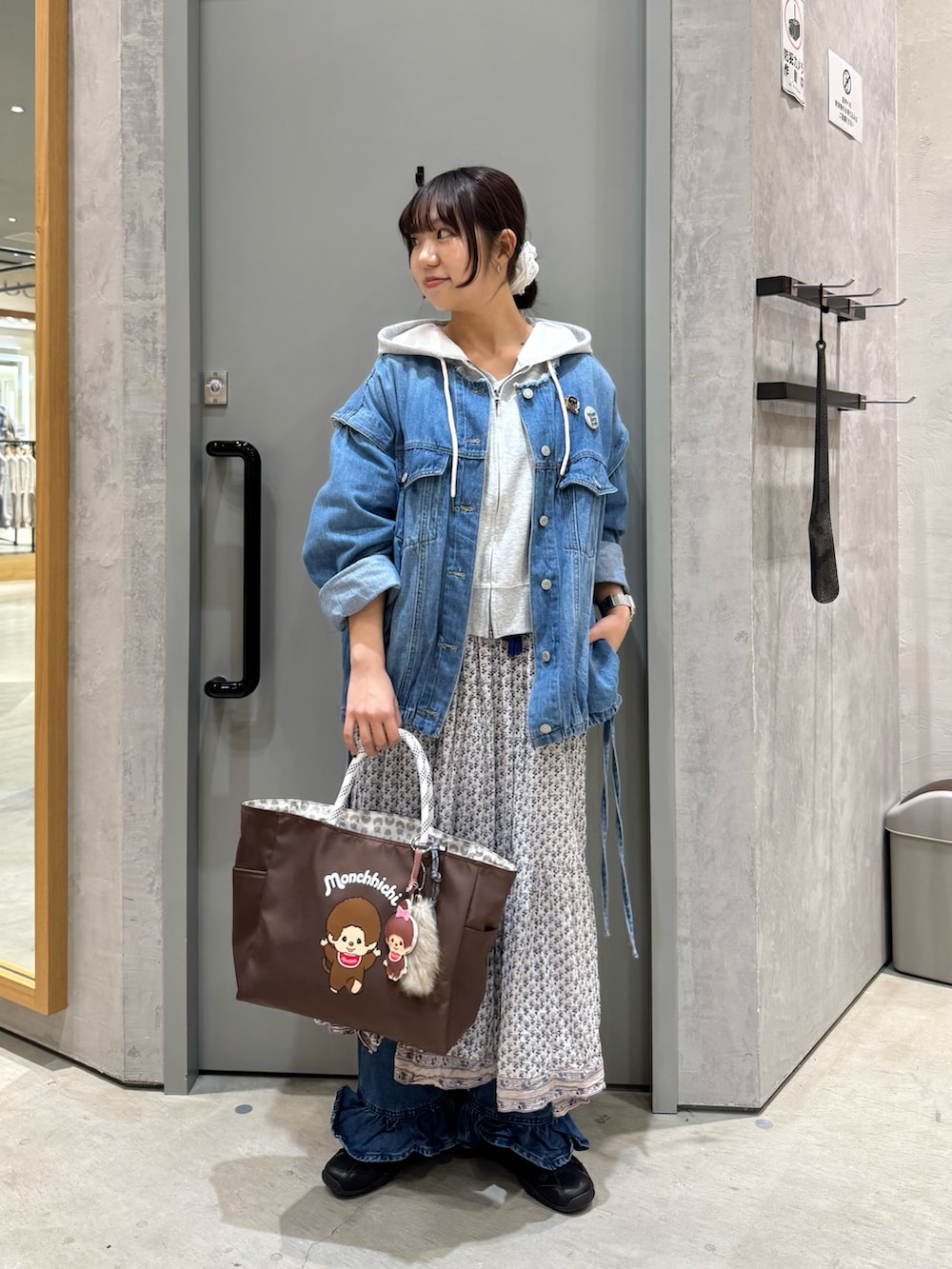 ブルー系のデニムジャケット、グレー系のパーカー、ブラウン系のショルダーバッグを着用したレディースの春コーディネートの2枚目の写真