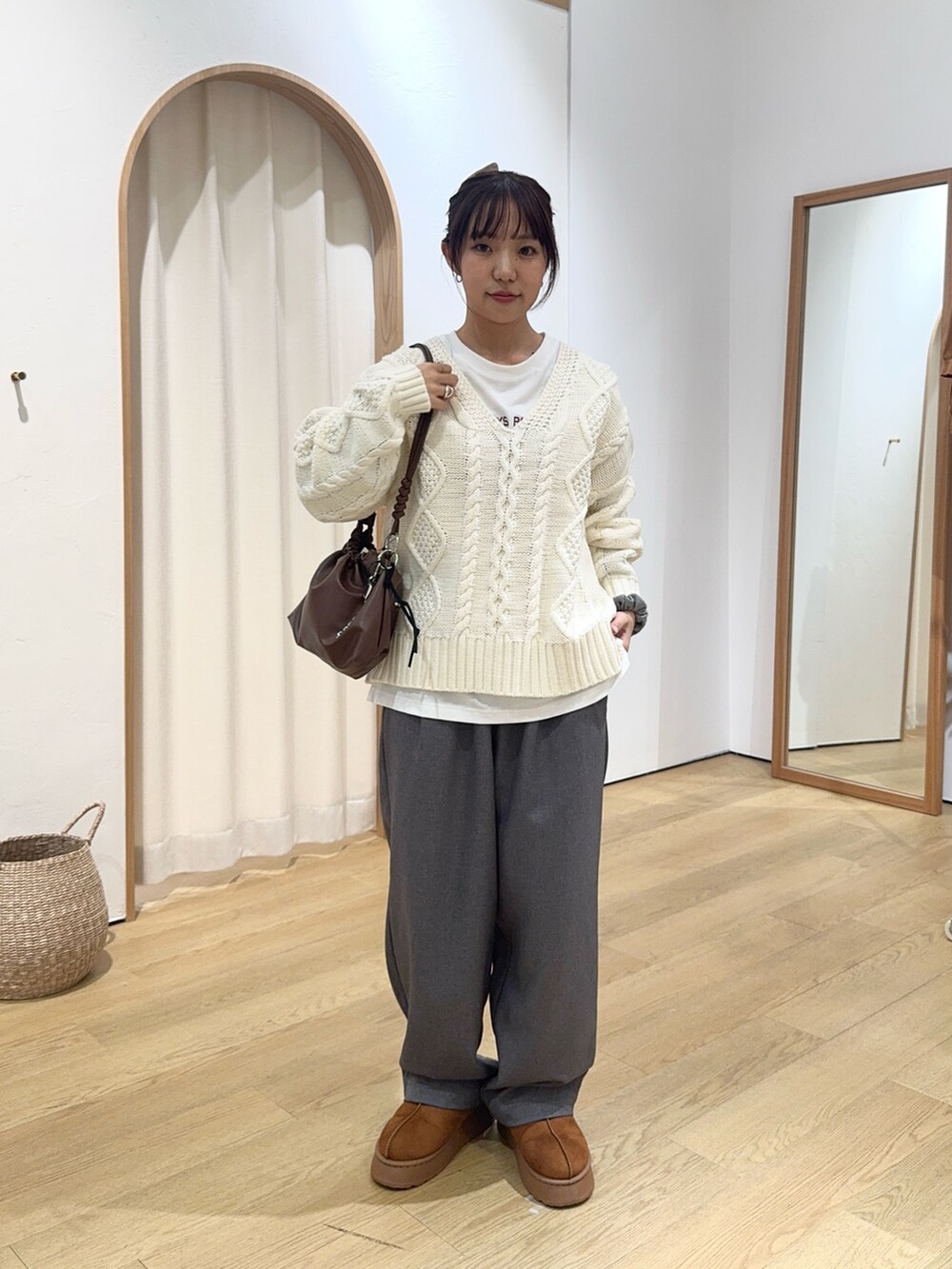 ホワイト系のニット/セーター、ホワイト系のTシャツ/カットソー、グレー系のスラックスを着用したレディースの秋コーディネートの2枚目の写真