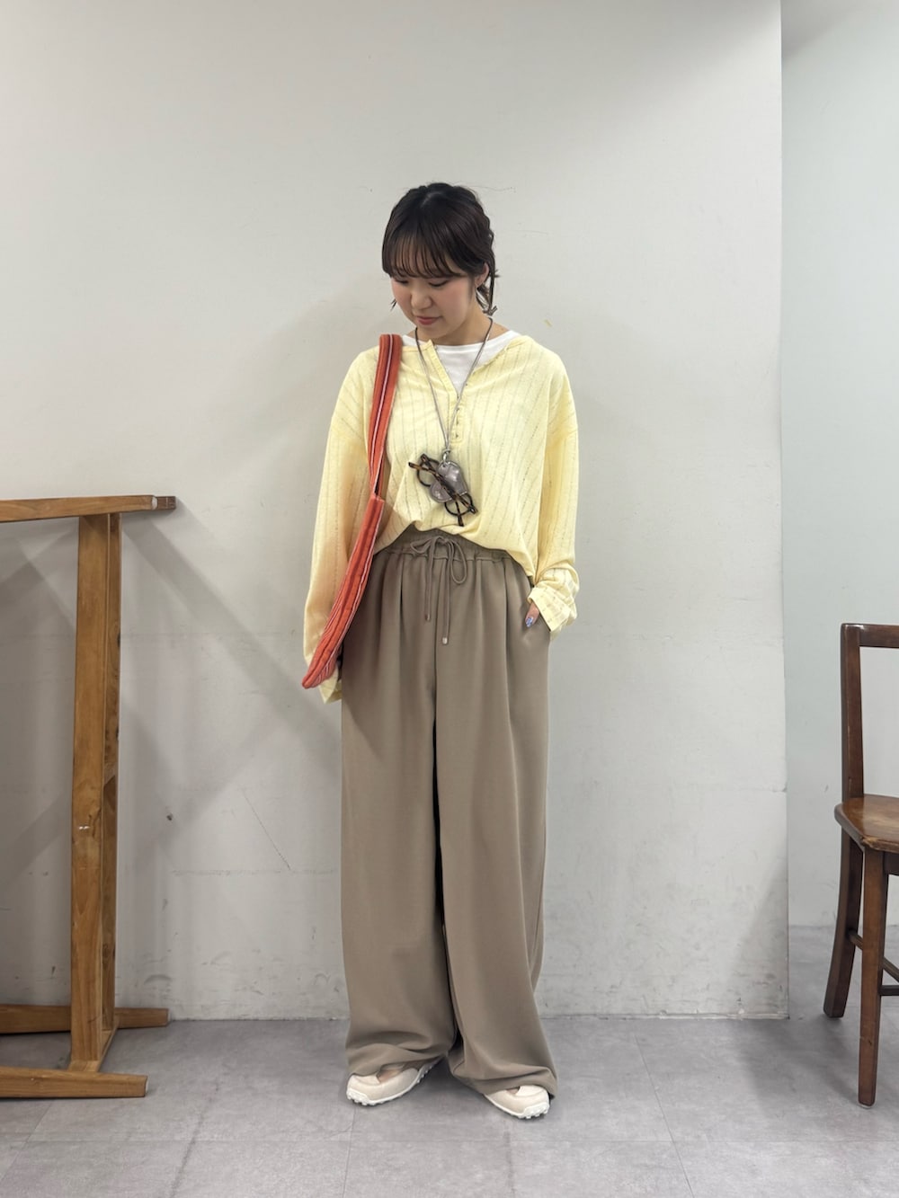 ベージュ系のスラックス、ホワイト系のスニーカー、イエロー系のTシャツ/カットソーを着用したレディースの春コーディネートの2枚目の写真