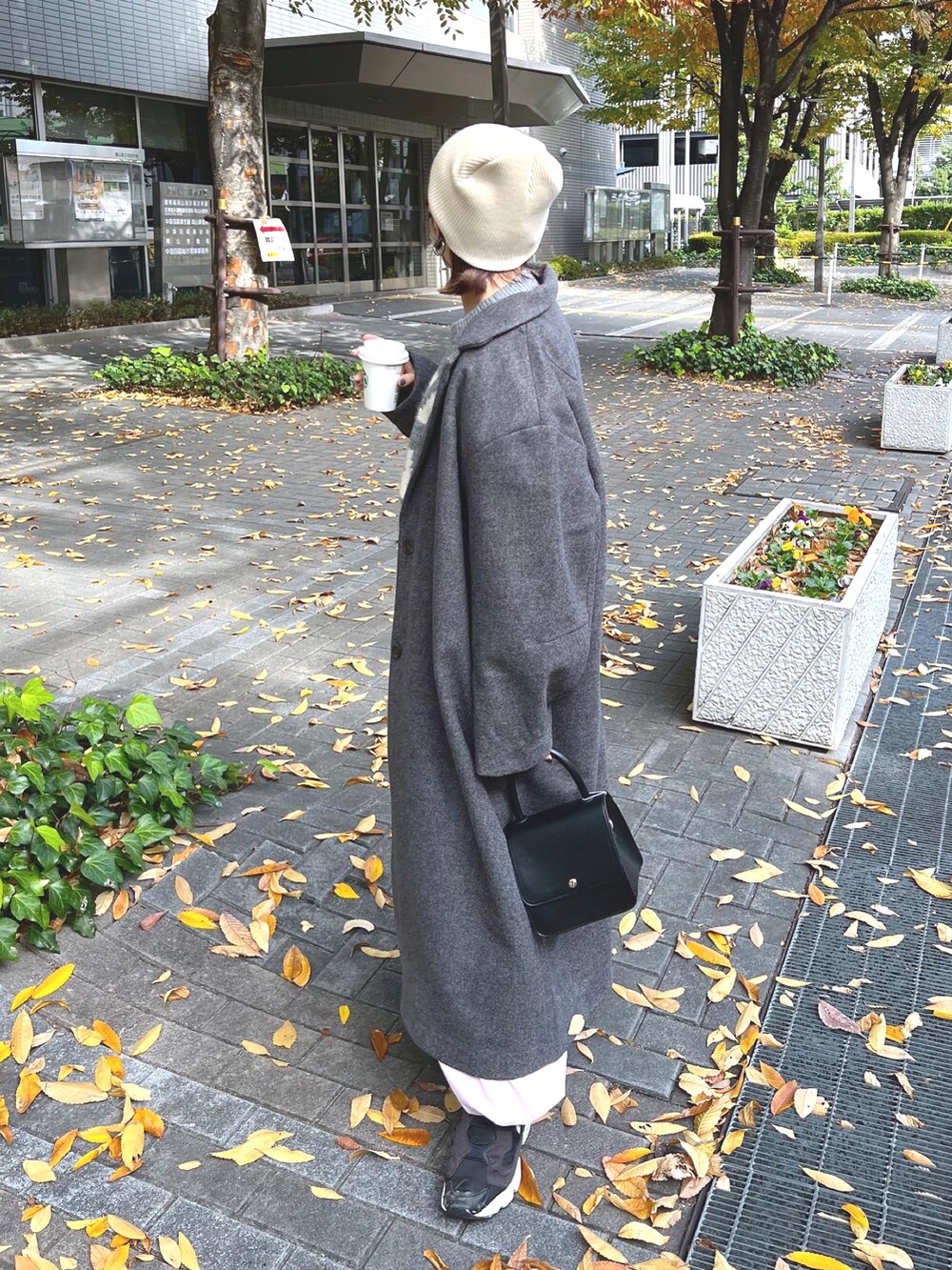 グレー系のニット/セーター、ピンク系のカーゴパンツ、ブラック系のスニーカーを着用したレディースの秋コーディネートの5枚目の写真