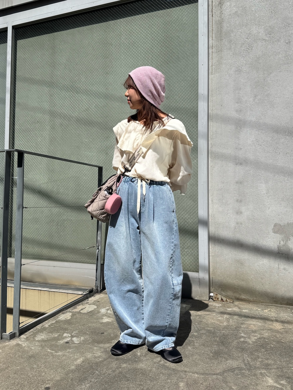 ホワイト系のTシャツ/カットソー、ブルー系のデニムパンツ、グレー系のショルダーバッグを着用したレディースの春コーディネートの2枚目の写真