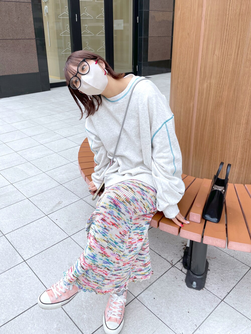 グレー系のスウェット、ピンク系のスカート、ピンク系のスニーカーを着用したレディースの秋コーディネートの4枚目の写真