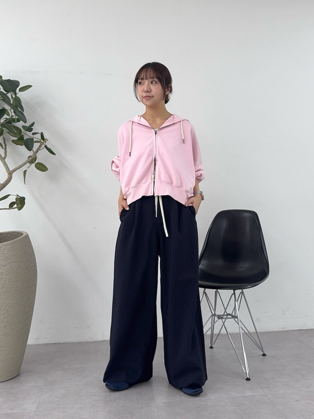 ピンク系のパーカー、ブラック系のスラックス、ブルー系のパンプスを着用したレディースの春コーディネートの2枚目の写真