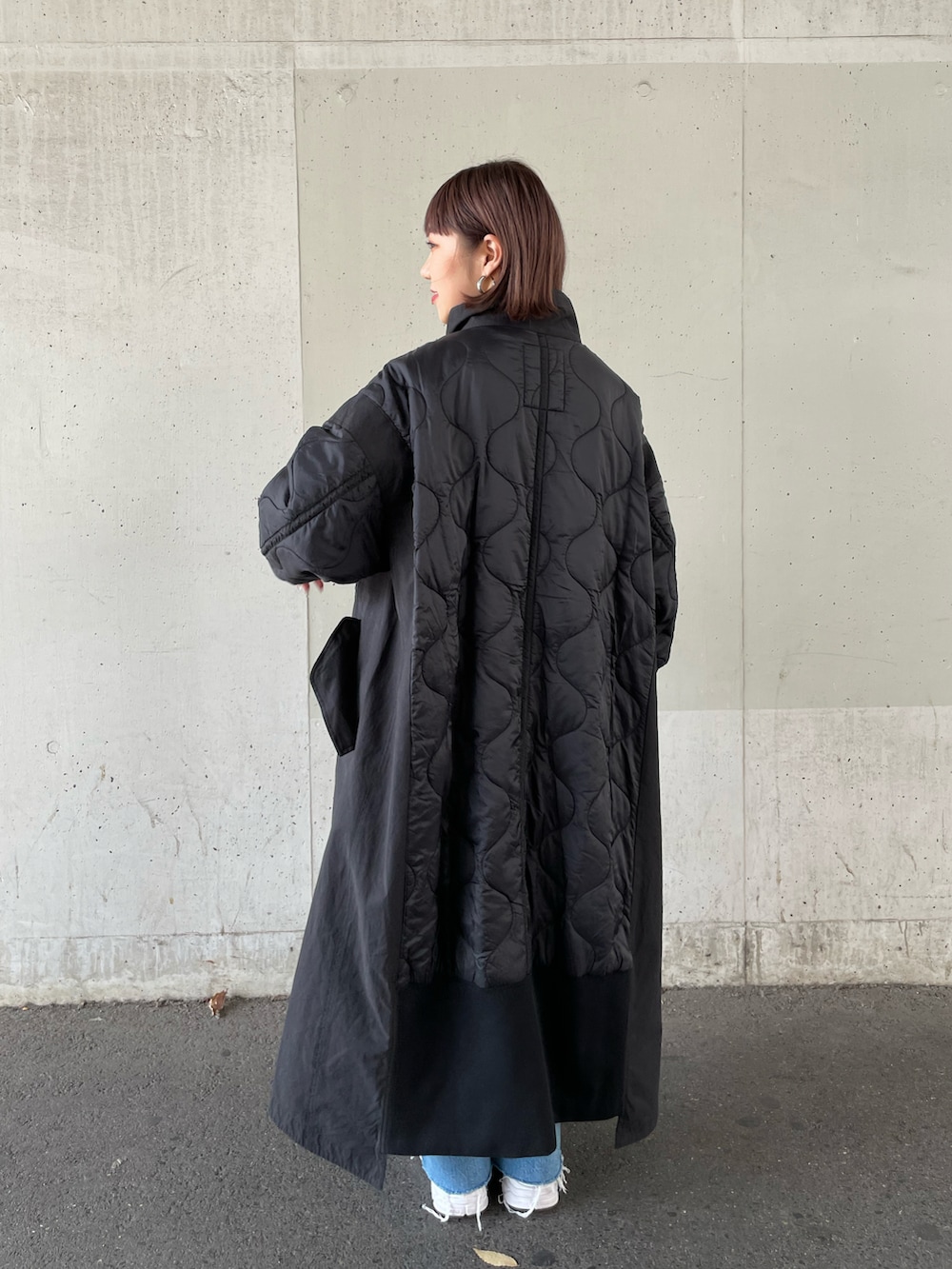 ピンク系のニット/セーター、ブラック系のその他アウター、ブルー系のデニムパンツを着用したレディースの秋コーディネートの5枚目の写真
