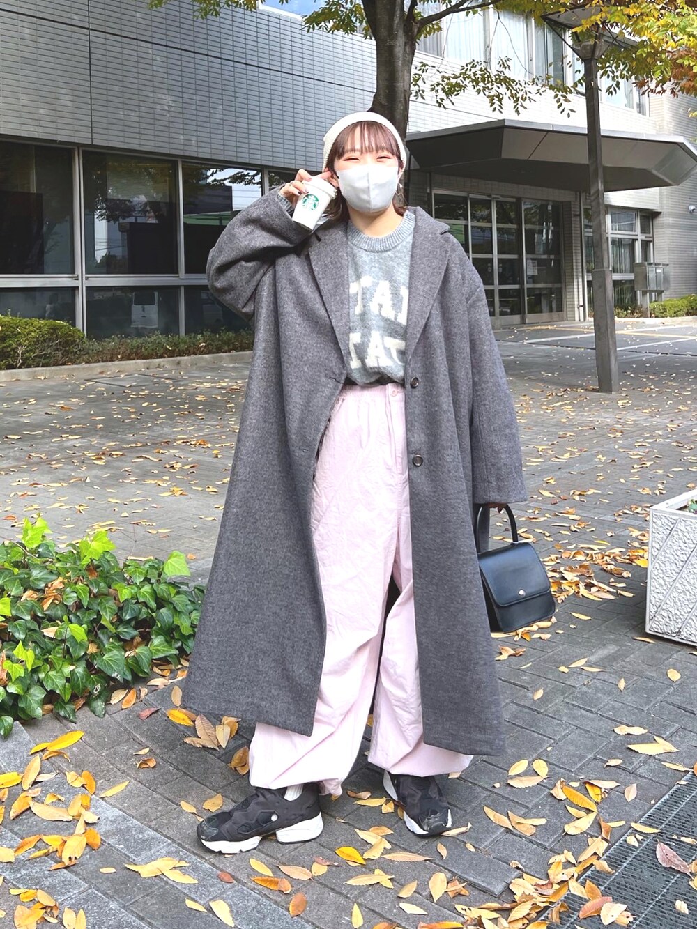 グレー系のニット/セーター、ピンク系のカーゴパンツ、ブラック系のスニーカーを着用したレディースの秋コーディネートの2枚目の写真