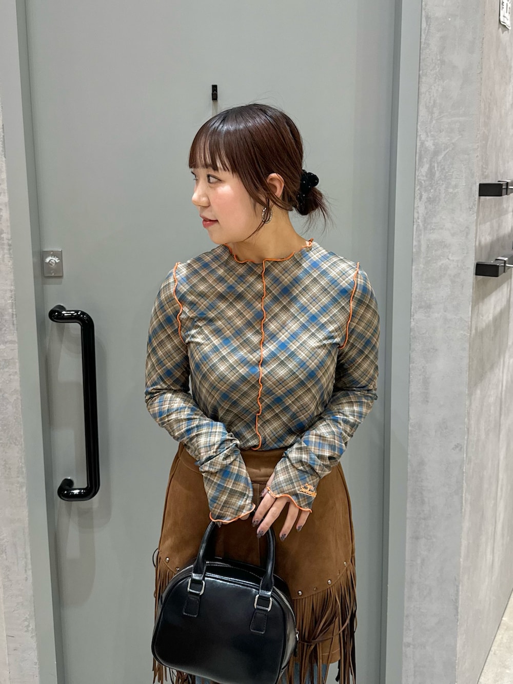 ブルー系のTシャツ/カットソー、ブラウン系のスカート、ブラック系のショルダーバッグを着用したレディースの春コーディネートの3枚目の写真