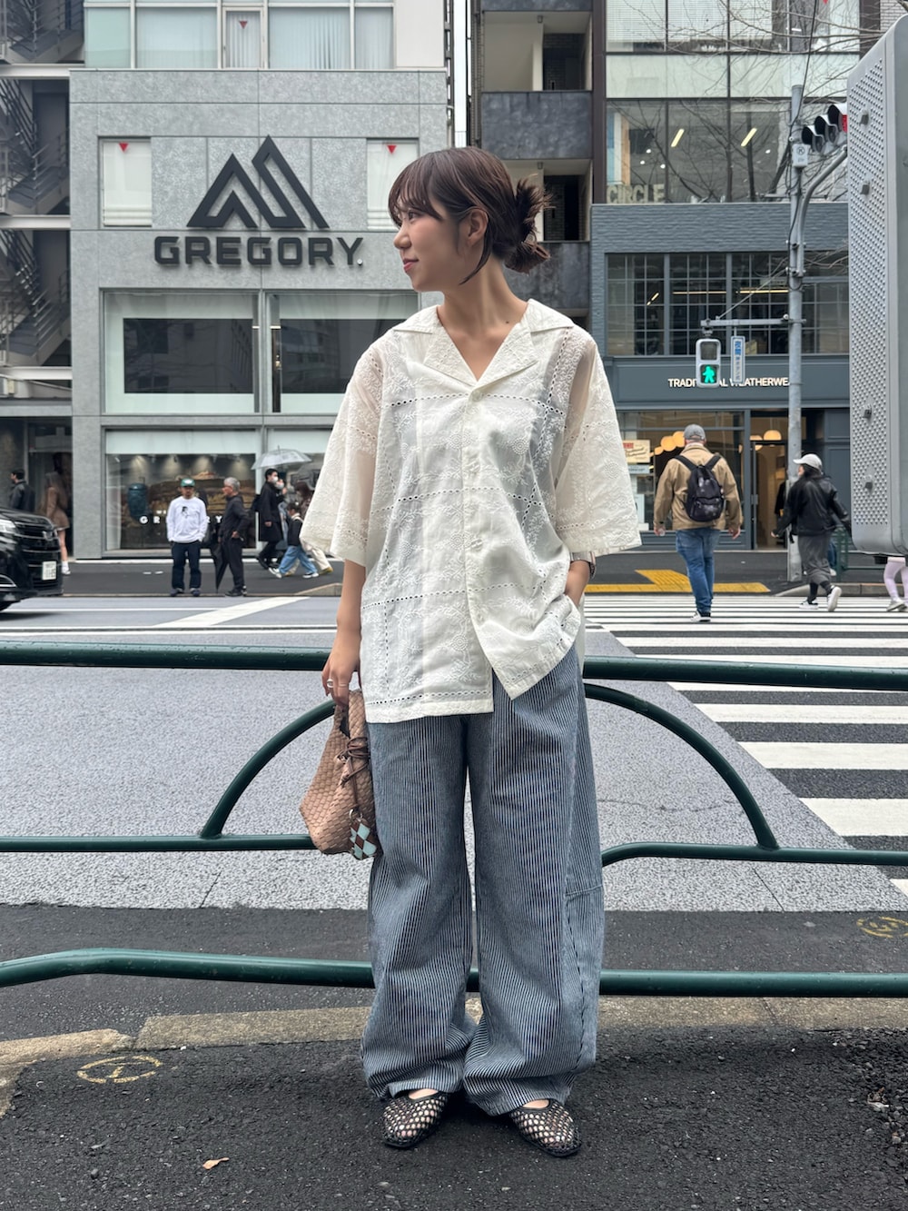ベージュ系のショルダーバッグ、ブルー系のデニムパンツ、ホワイト系のシャツ/ブラウスを着用したレディースの春コーディネートの2枚目の写真