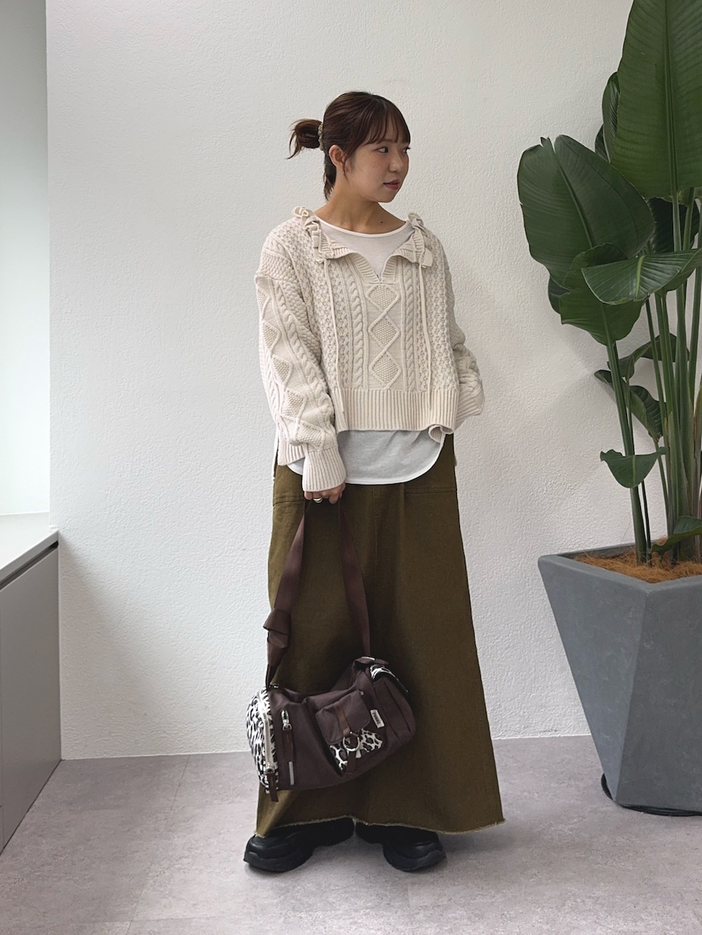 ホワイト系のニット/セーター、ホワイト系のTシャツ/カットソー、ブラウン系のトートバッグを着用したレディースの秋コーディネートの2枚目の写真