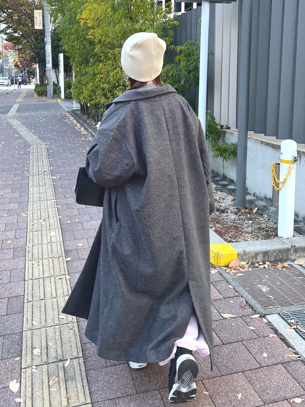 グレー系のニット/セーター、ピンク系のカーゴパンツ、ブラック系のスニーカーを着用したレディースの秋コーディネートの4枚目の写真