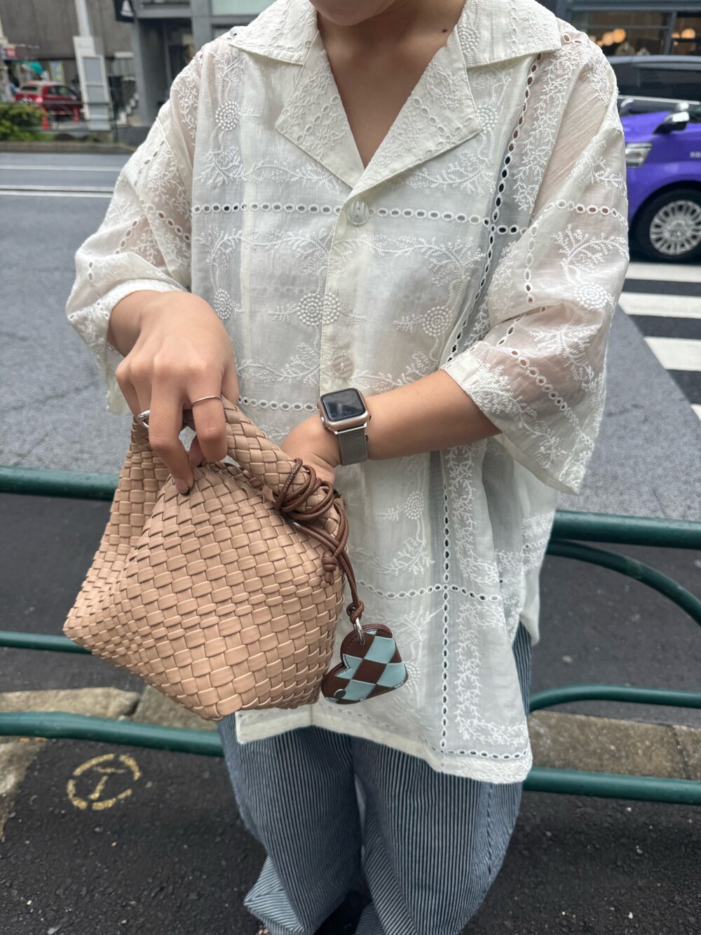 ベージュ系のショルダーバッグ、ブルー系のデニムパンツ、ホワイト系のシャツ/ブラウスを着用したレディースの春コーディネートの3枚目の写真