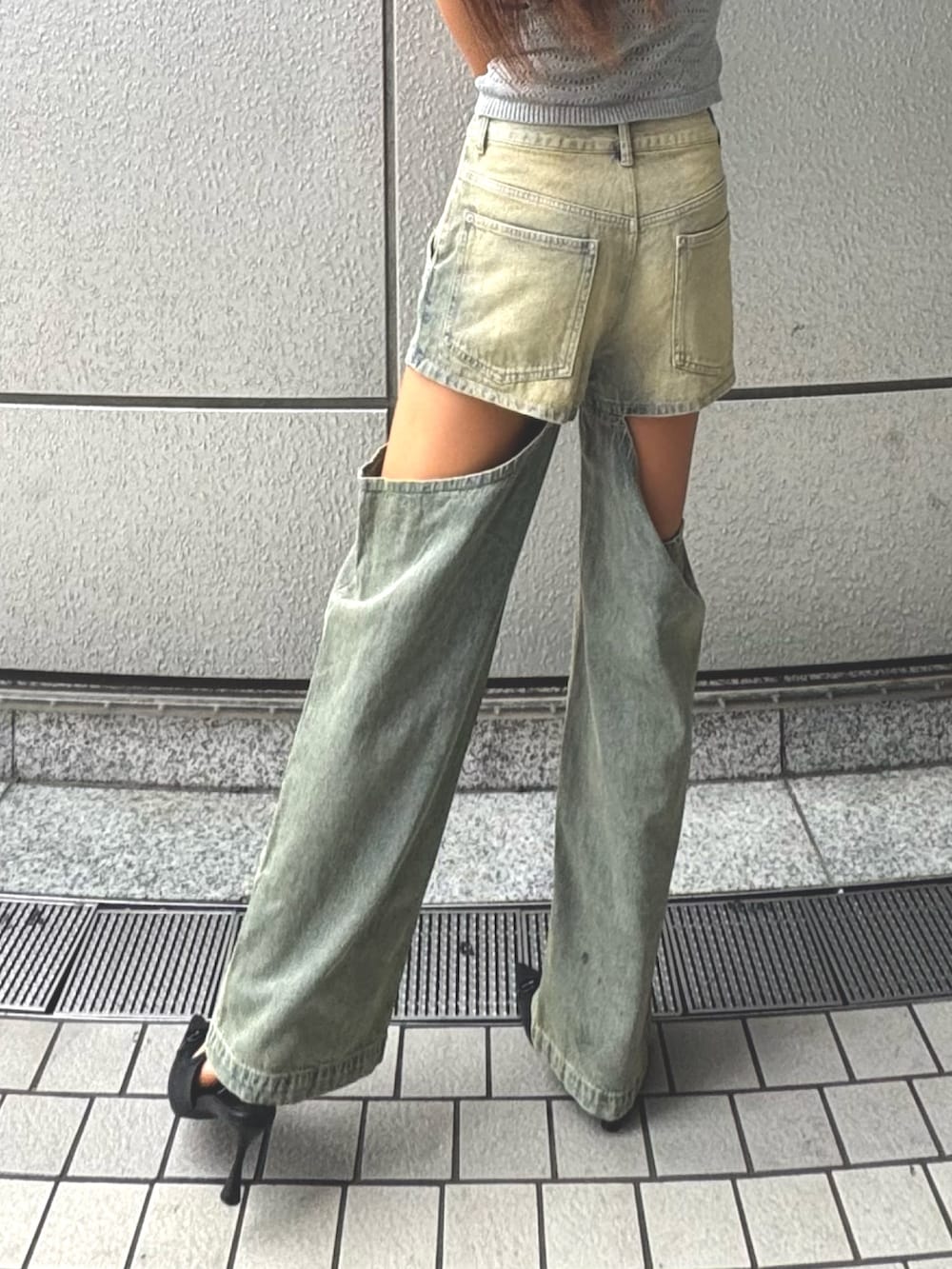 ブルー系のデニムパンツ、ブラック系のパンプス、グレー系のタンクトップを着用したレディースの夏コーディネートの2枚目の写真