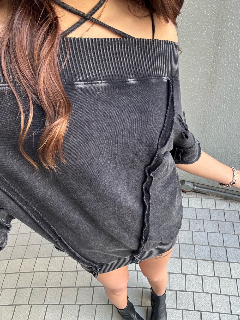 ブラック系のワンピース、ブラック系のブーツを着用したレディースの春コーディネートの2枚目の写真