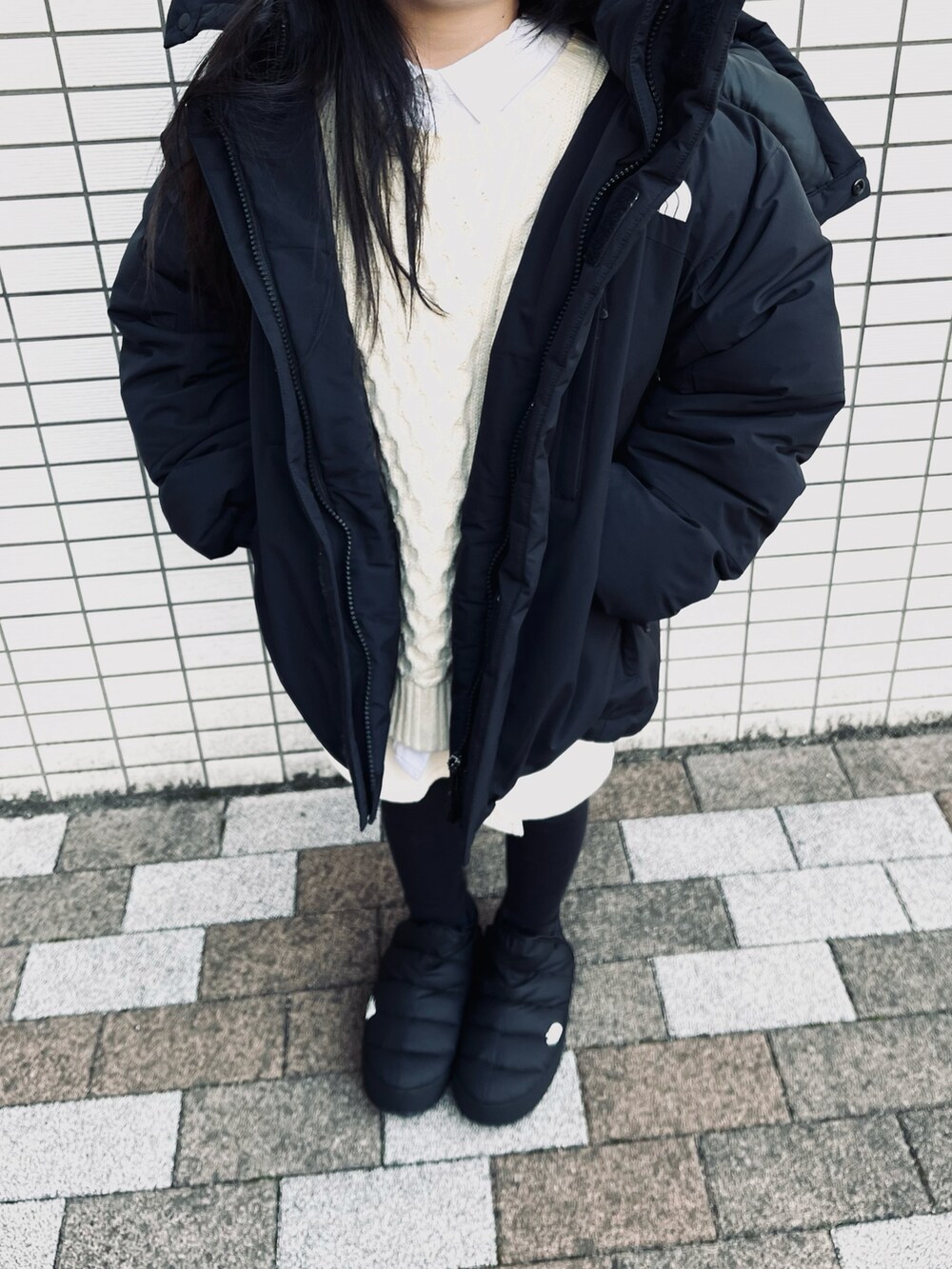 ブラック系のダウンジャケット/コート、ブラック系のブーツ、ベージュ系のベストを着用したキッズの冬コーディネートの2枚目の写真