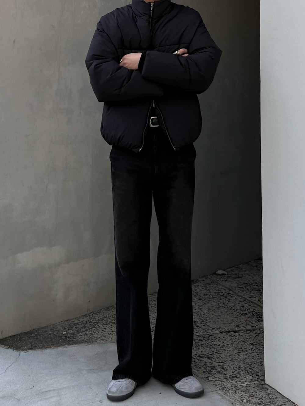 ブラック系のダウンジャケット/コート、ブラウン系のデニムパンツ、グレー系のスニーカーを着用したメンズの冬コーディネートの5枚目の写真