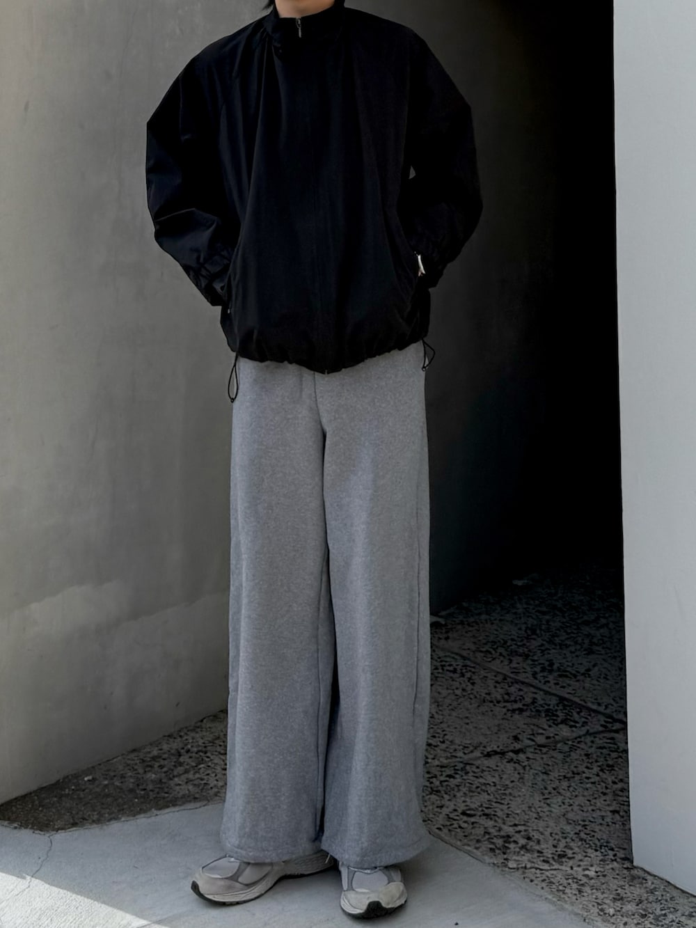 ブラック系のブルゾン、グレー系のスウェットパンツ、グレー系のスニーカーを着用したメンズの冬コーディネートの2枚目の写真