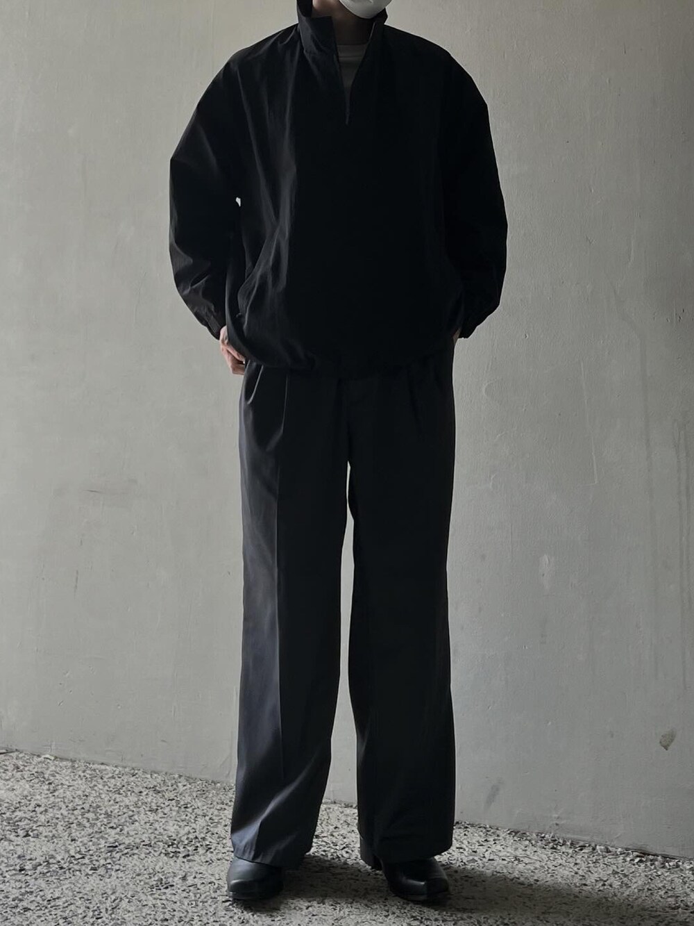 グレー系のTシャツ/カットソー、ブラック系のブルゾン、グレー系のスラックスを着用したメンズの春コーディネートの4枚目の写真