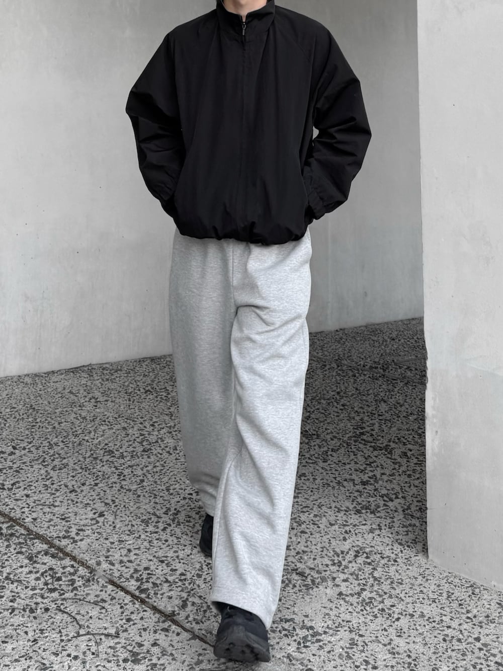 グレー系のスウェットパンツ、ブラック系のブルゾン、ブラック系のスニーカーを着用したメンズの春コーディネートの4枚目の写真