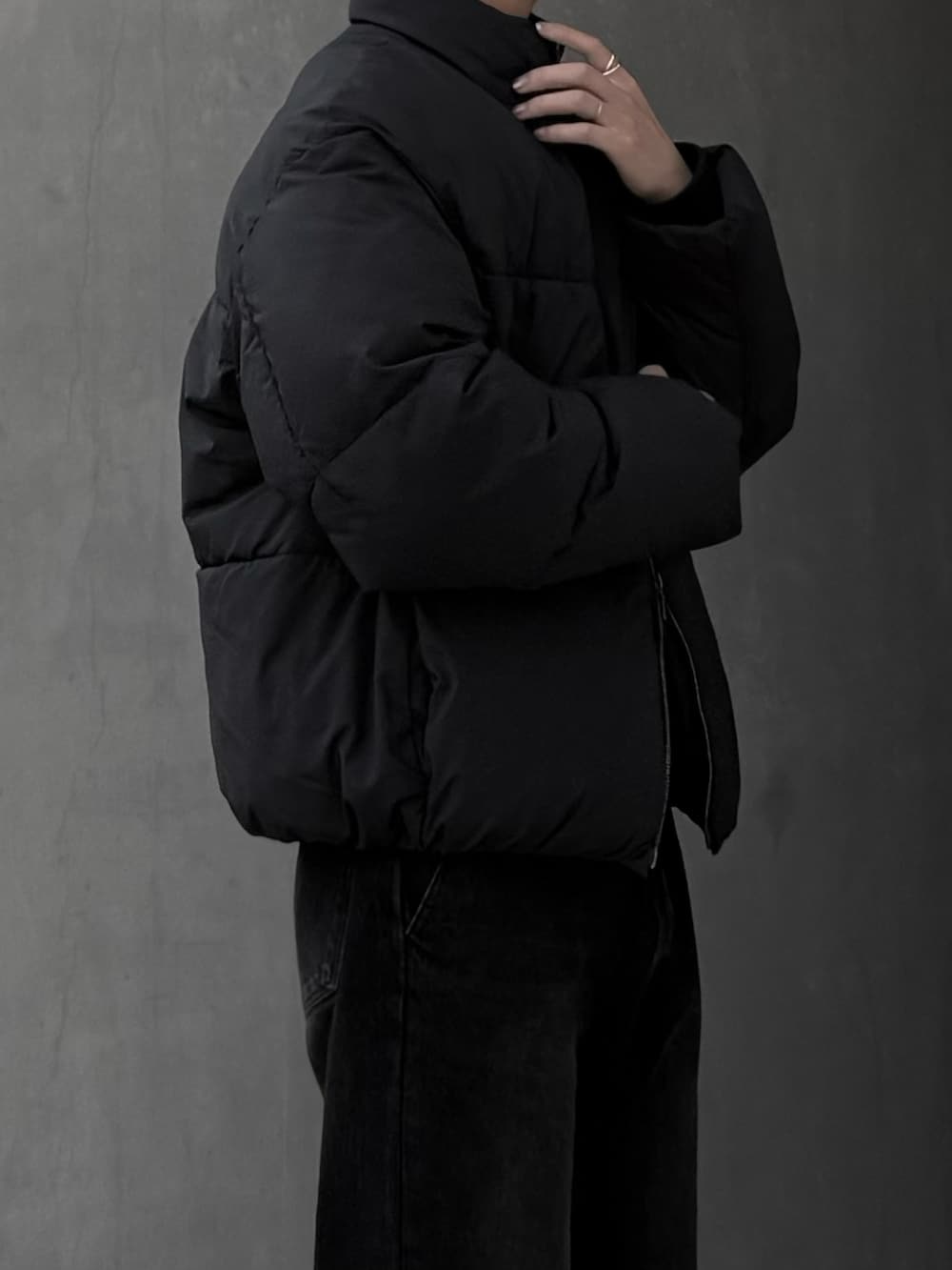 ブラック系のダウンジャケット/コート、ブラウン系のデニムパンツ、グレー系のスニーカーを着用したメンズの冬コーディネートの3枚目の写真