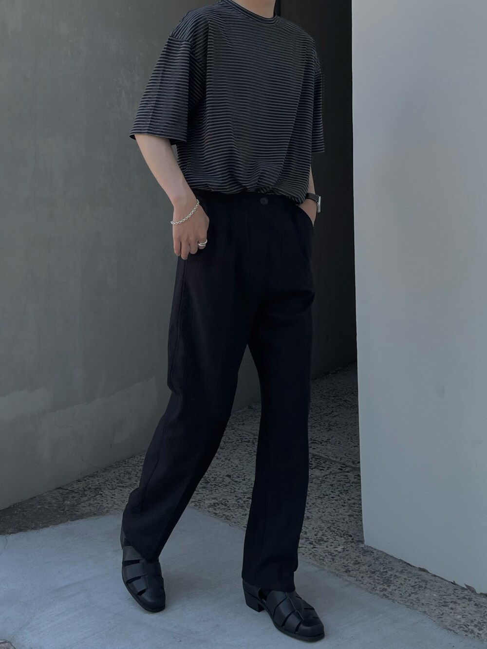 ブラック系のサンダル、ブラック系のスラックス、ブラック系のTシャツ/カットソーを着用したメンズの夏コーディネートの4枚目の写真