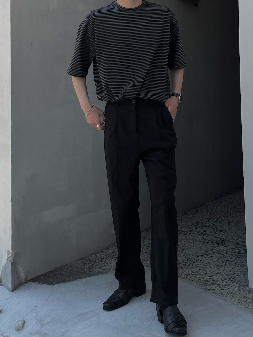 ブラック系のサンダル、ブラック系のスラックス、ブラック系のTシャツ/カットソーを着用したメンズの夏コーディネートの2枚目の写真