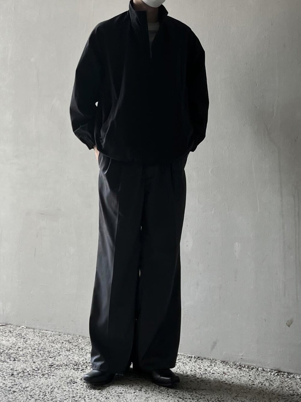 グレー系のTシャツ/カットソー、ブラック系のブルゾン、グレー系のスラックスを着用したメンズの春コーディネートの5枚目の写真