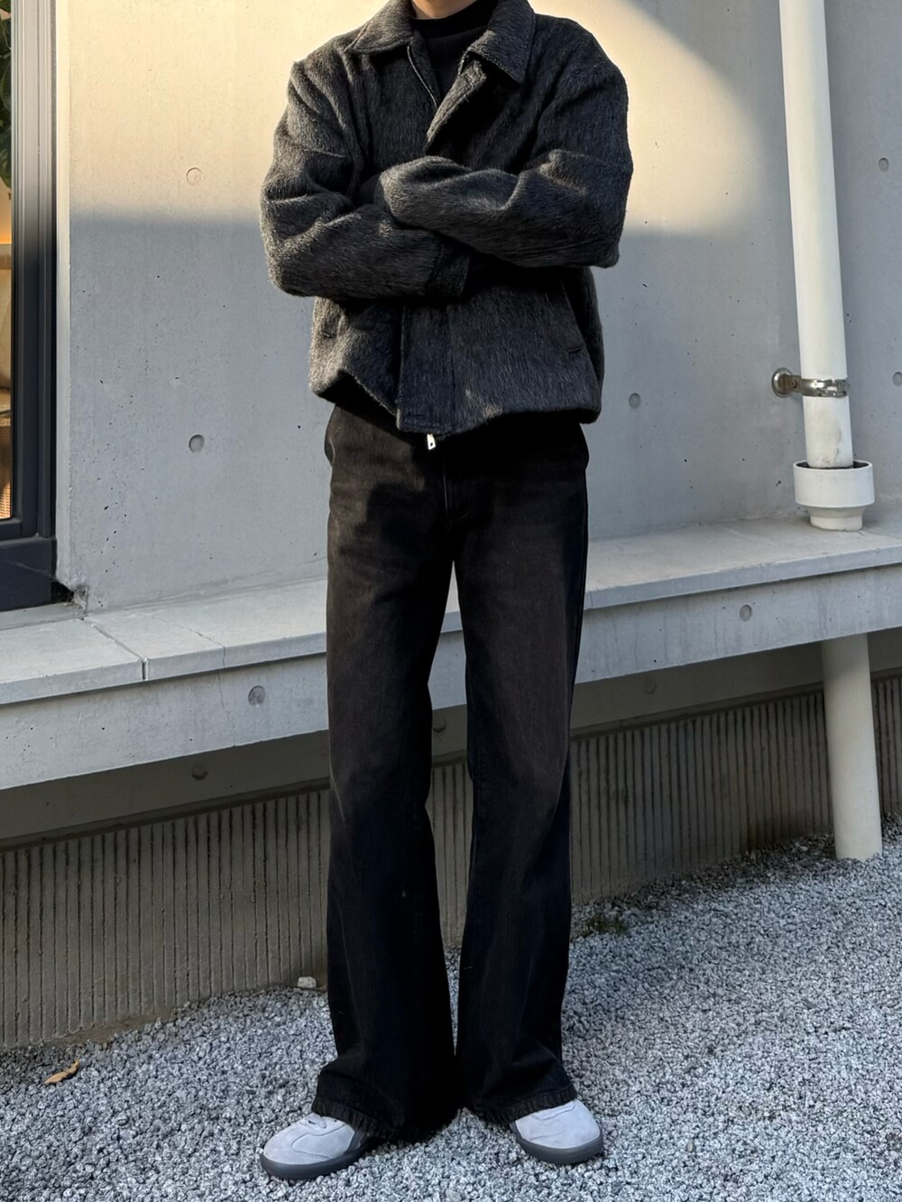 ブラウン系のデニムパンツ、グレー系のスニーカーを着用したメンズの冬コーディネートの4枚目の写真