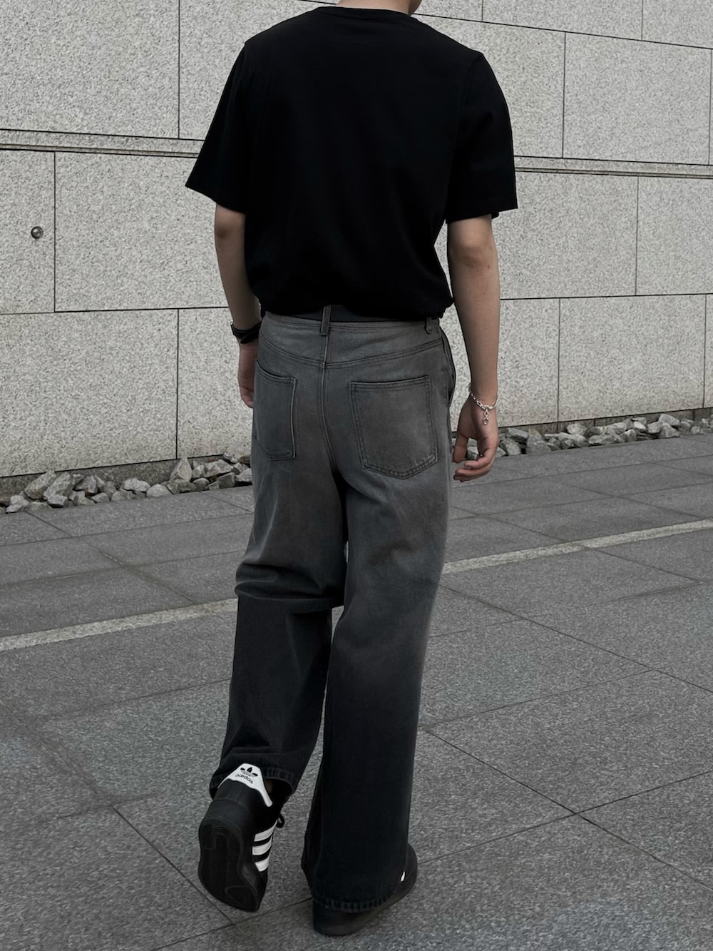 ブラック系のTシャツ/カットソー、その他のデニムパンツ、ブラック系のスニーカーを着用したメンズの夏コーディネートの4枚目の写真