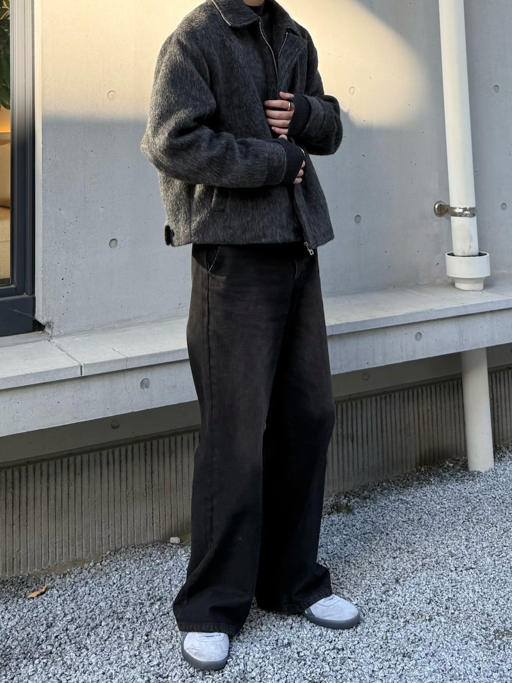 ブラウン系のデニムパンツ、グレー系のスニーカーを着用したメンズの冬コーディネートの3枚目の写真