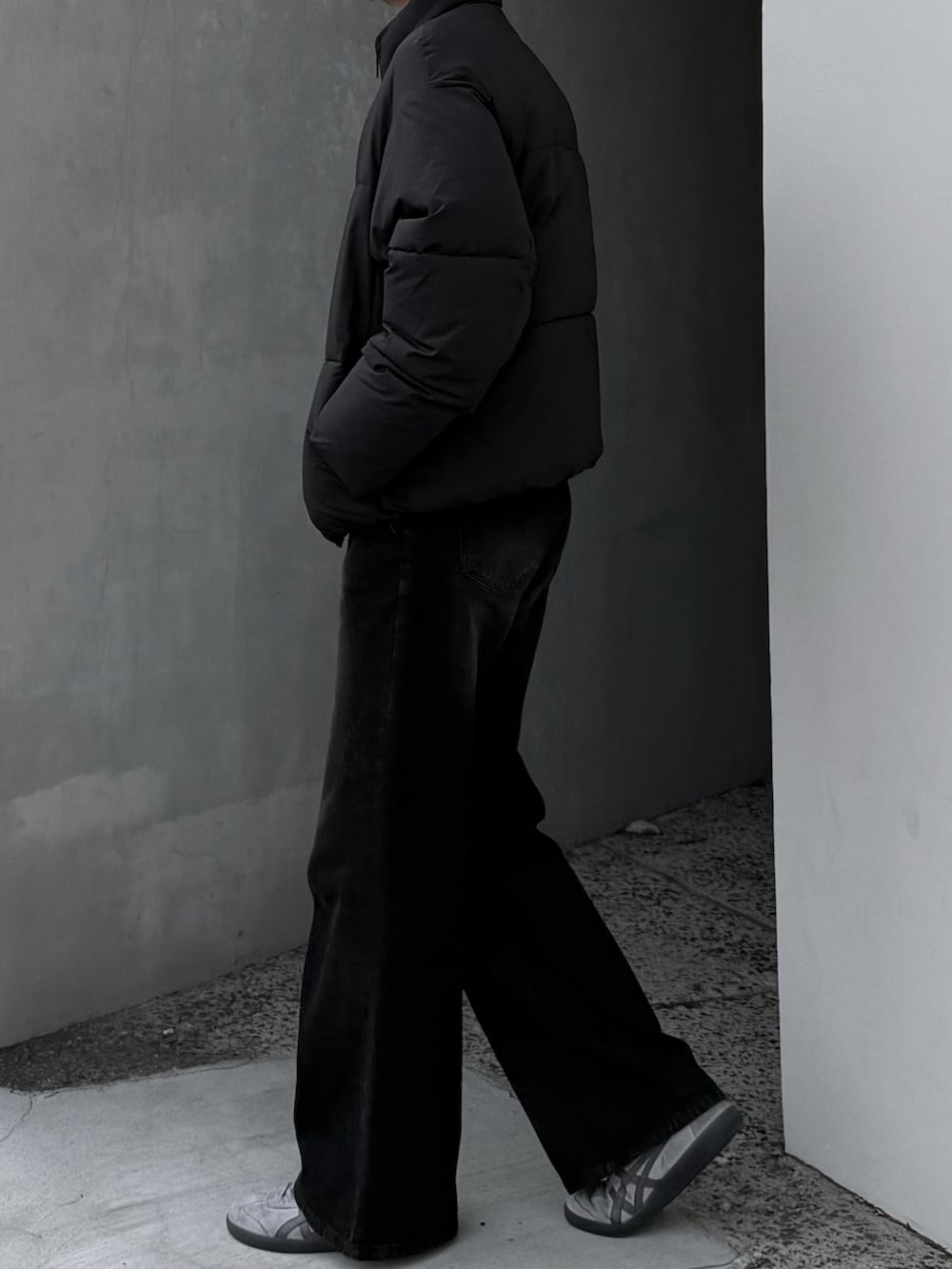 ブラック系のダウンジャケット/コート、ブラウン系のデニムパンツ、グレー系のスニーカーを着用したメンズの冬コーディネートの4枚目の写真