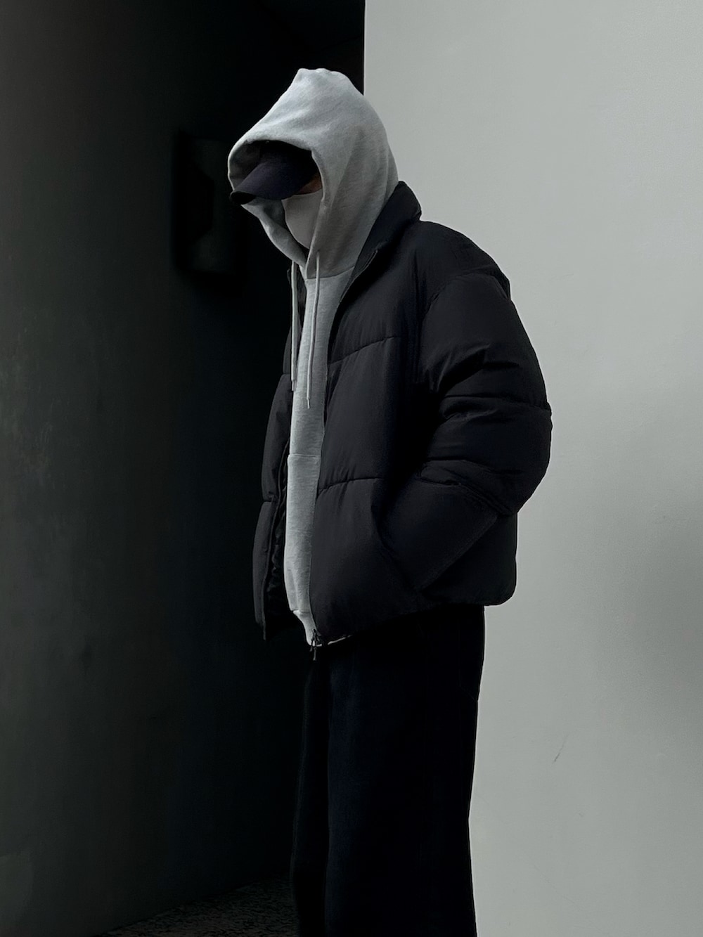 ブラック系のデニムパンツ、ブラック系のダウンジャケット/コート、グレー系のパーカーを着用したメンズの冬コーディネートの3枚目の写真