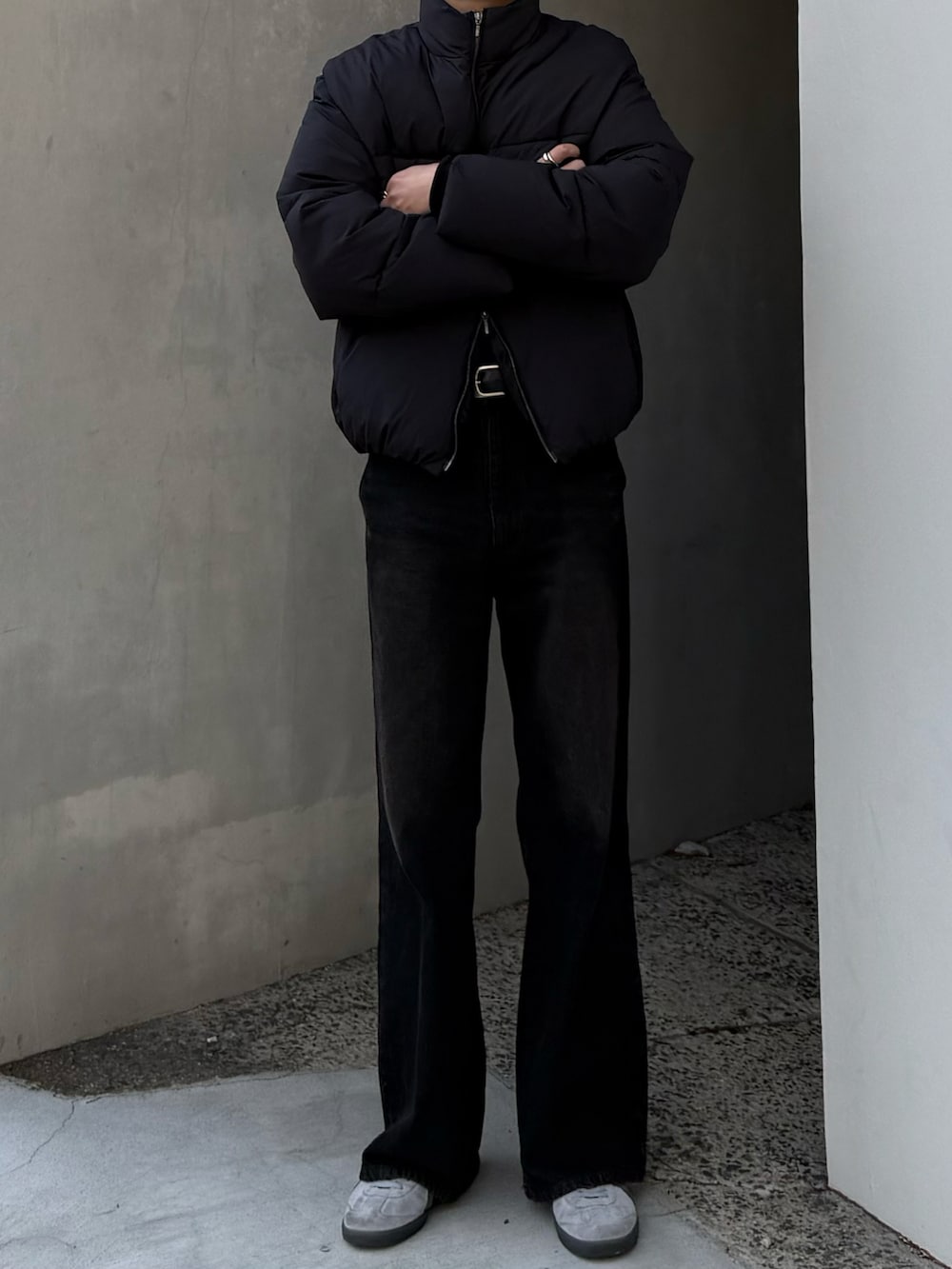 ブラック系のダウンジャケット/コート、ブラウン系のデニムパンツ、グレー系のスニーカーを着用したメンズの冬コーディネートの2枚目の写真