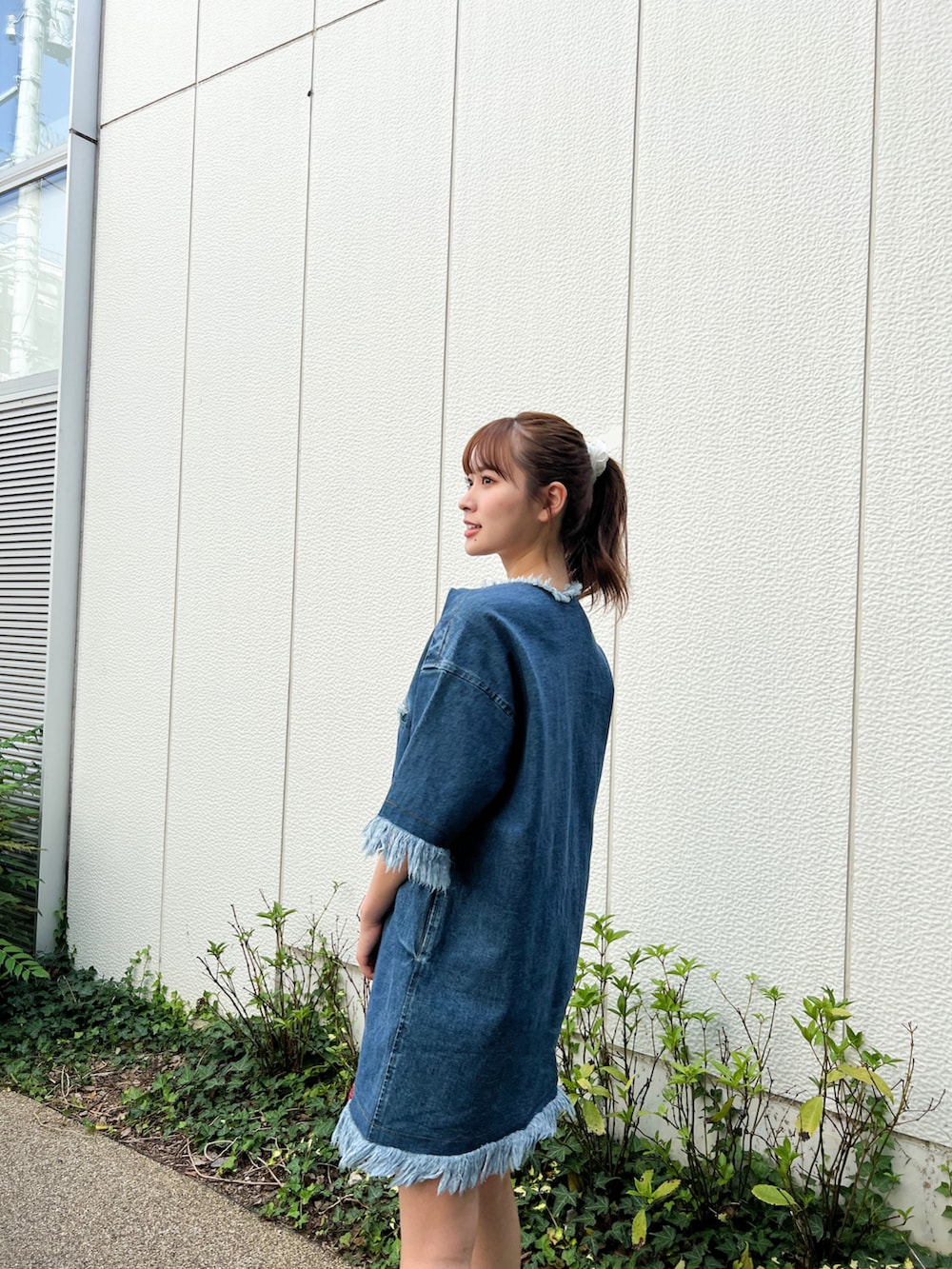 ホワイト系のスニーカー、ブルー系のワンピース、レッド系のショルダーバッグを着用したレディースの夏コーディネートの2枚目の写真